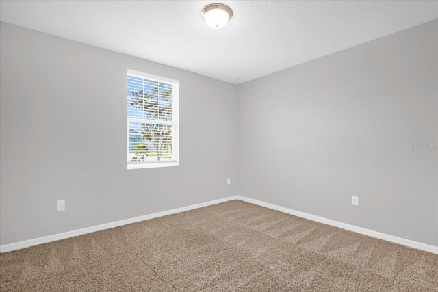 empty room with baseboards and carpet