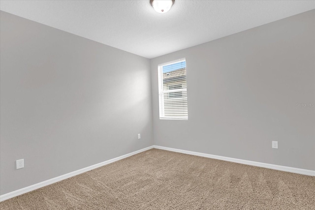 carpeted empty room with baseboards