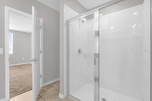 full bath with tile patterned flooring, a stall shower, and baseboards