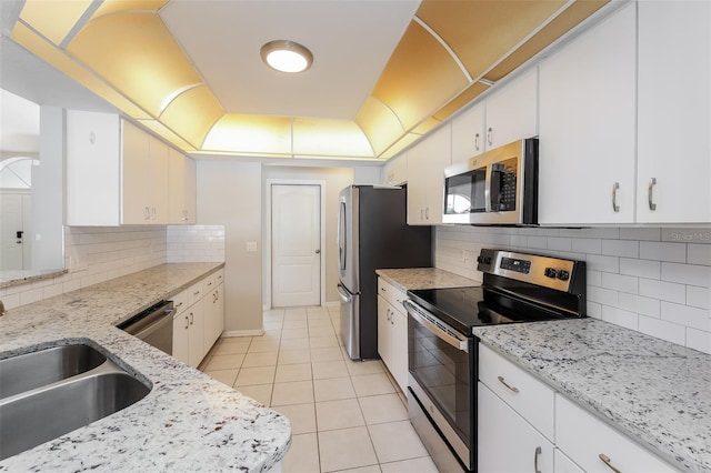 kitchen with white cabinetry, decorative backsplash, light stone countertops, and stainless steel appliances