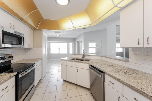 kitchen with backsplash, sink, white cabinetry, and appliances with stainless steel finishes