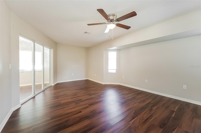 spare room featuring dark wood-type flooring, a healthy amount of sunlight, and ceiling fan