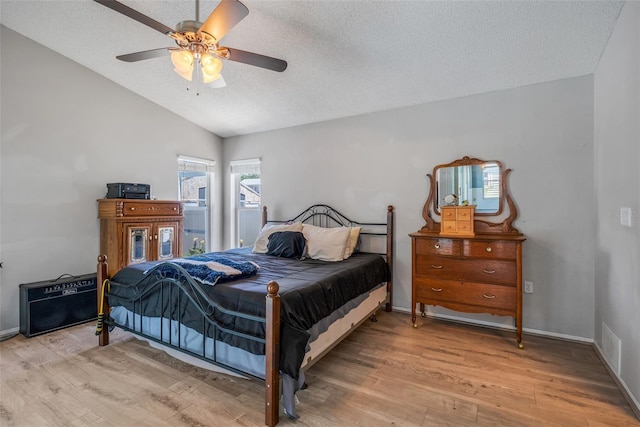 bedroom featuring hardwood / wood-style floors, a textured ceiling, ceiling fan, and vaulted ceiling