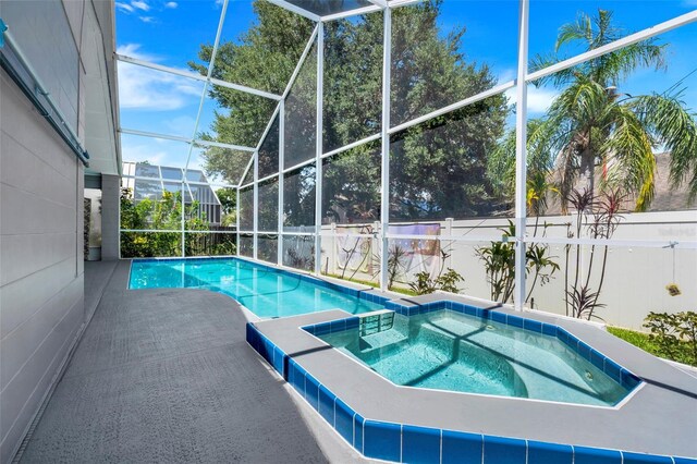 view of pool featuring an in ground hot tub, a patio, and a lanai