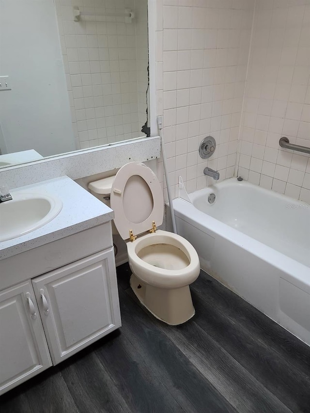 full bathroom featuring vanity, wood-type flooring, tiled shower / bath combo, and toilet