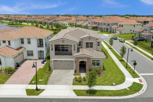 mediterranean / spanish home featuring a front yard, a balcony, and a garage