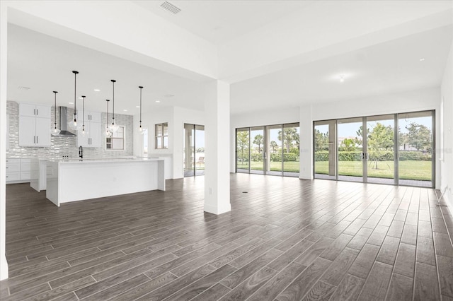 unfurnished living room featuring dark hardwood / wood-style flooring and a wealth of natural light