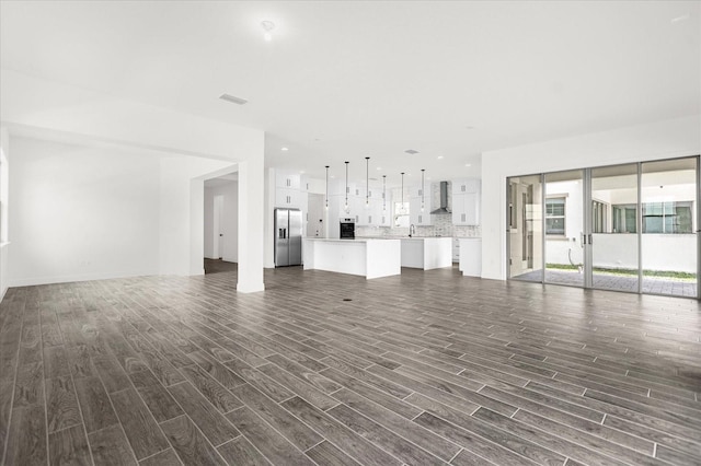 unfurnished living room featuring dark hardwood / wood-style floors and sink