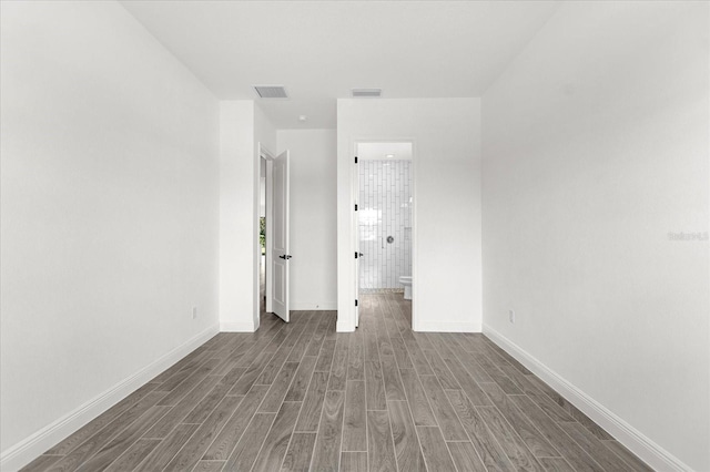 unfurnished room with dark wood-type flooring