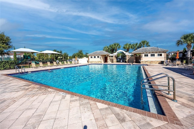 view of swimming pool with a patio area and an outdoor structure