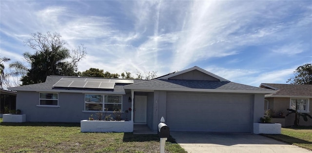 ranch-style home featuring a front lawn, a garage, and solar panels