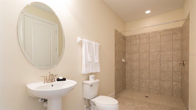 bathroom featuring tiled shower and toilet