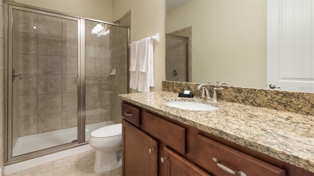 bathroom featuring vanity, walk in shower, tile patterned flooring, and toilet