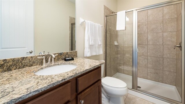 bathroom with toilet, vanity, and an enclosed shower