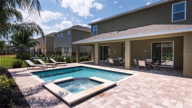 view of pool with an in ground hot tub and a patio