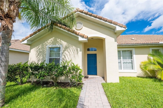 view of exterior entry with a yard