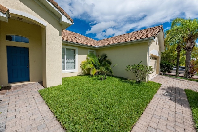 view of side of property featuring a lawn and a garage