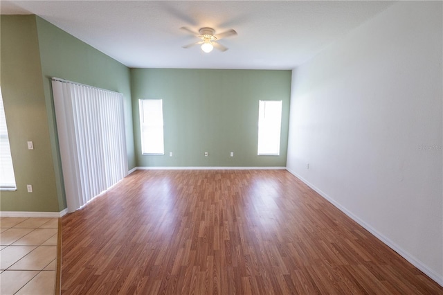 empty room with ceiling fan and light hardwood / wood-style flooring