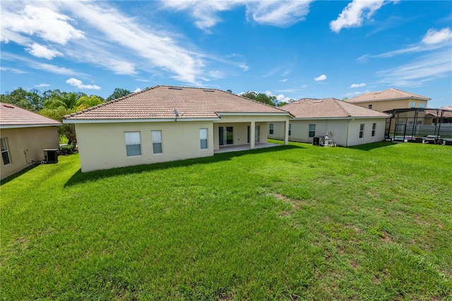 back of property with a yard, central AC unit, and a patio area