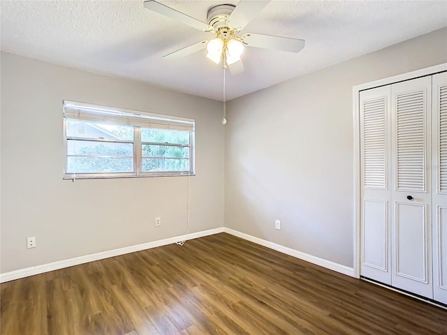 unfurnished bedroom with a textured ceiling, dark hardwood / wood-style flooring, a closet, and ceiling fan