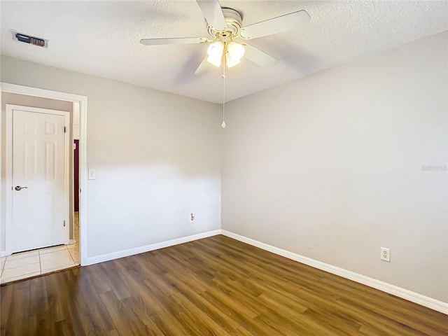 empty room with hardwood / wood-style flooring, ceiling fan, and a textured ceiling