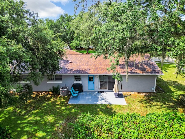 back of property featuring a yard, cooling unit, and a patio