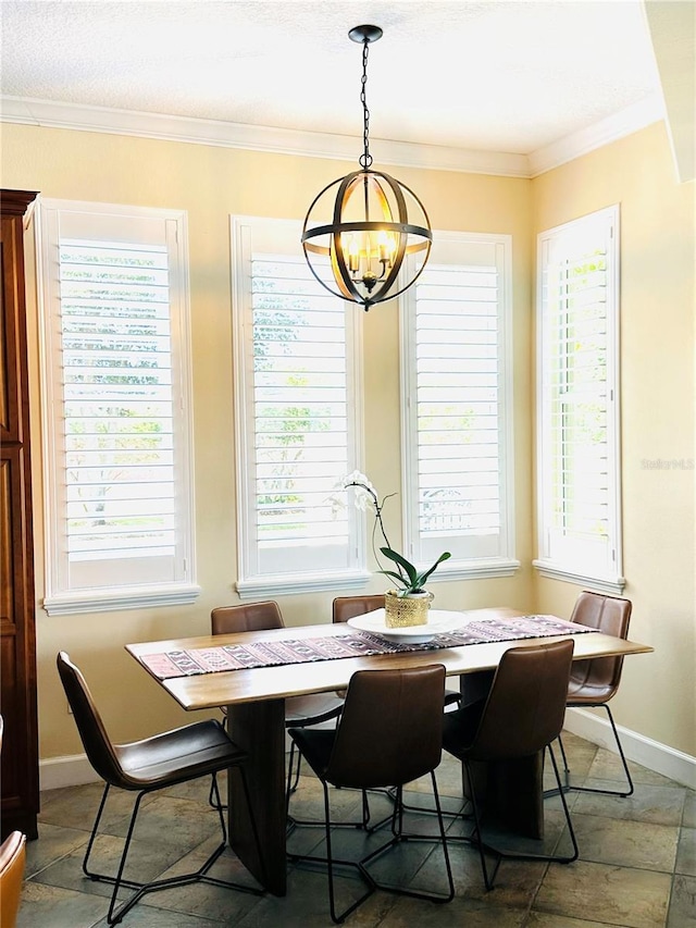 dining area with a notable chandelier, baseboards, and ornamental molding