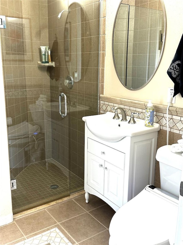 full bathroom featuring tile patterned flooring, toilet, vanity, and a stall shower