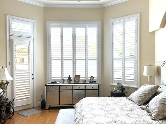 bedroom with crown molding and wood finished floors