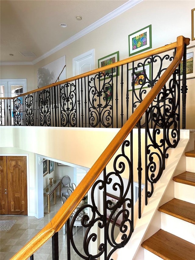 stairway with ornamental molding and a towering ceiling