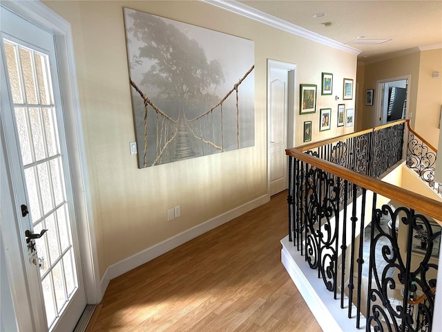 corridor with light wood-style flooring, baseboards, a healthy amount of sunlight, and ornamental molding