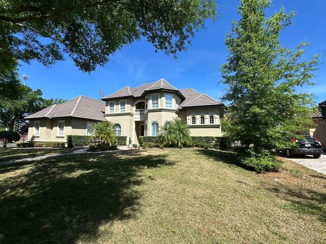 8734 Crestgate Cir, Orlando, FL 32819 - french country home featuring stucco siding and a front yard