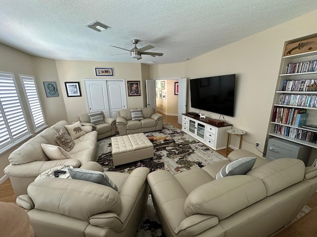 8734 Crestgate Cir, Orlando, FL 32819 - living room with ceiling fan, a textured ceiling, and baseboards