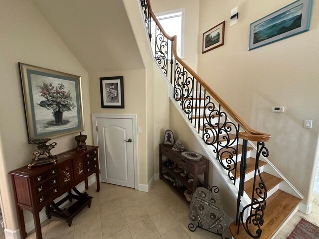 8734 Crestgate Cir, Orlando, FL 32819 - stairway with lofted ceiling, baseboards, and tile patterned floors