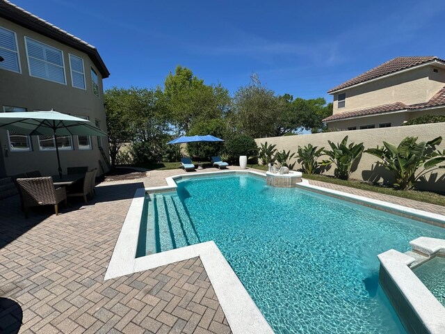 8734 Crestgate Cir, Orlando, FL 32819 - view of swimming pool featuring a patio area, a fenced backyard, and a pool with connected hot tub