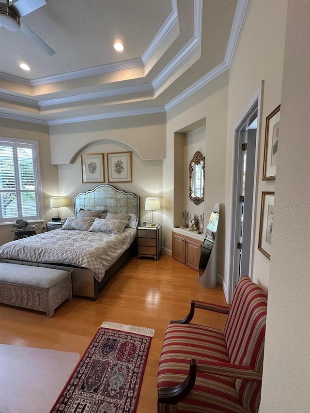 8734 Crestgate Cir, Orlando, FL 32819 - bedroom with crown molding, light wood-style flooring, a raised ceiling, and ceiling fan