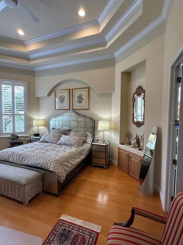 8734 Crestgate Cir, Orlando, FL 32819 - bedroom featuring a raised ceiling, ornamental molding, light wood-type flooring, and recessed lighting