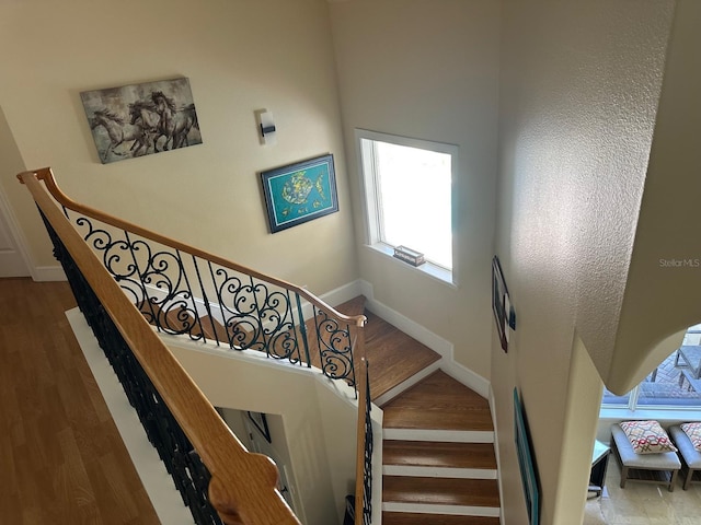 8734 Crestgate Cir, Orlando, FL 32819 - staircase featuring baseboards, wood finished floors, and a high ceiling