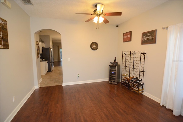 unfurnished room featuring a textured ceiling, dark hardwood / wood-style flooring, and ceiling fan