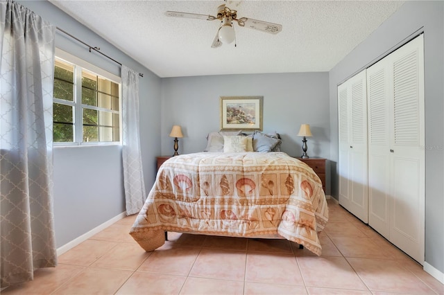 bedroom with light tile patterned floors, a textured ceiling, a closet, and ceiling fan