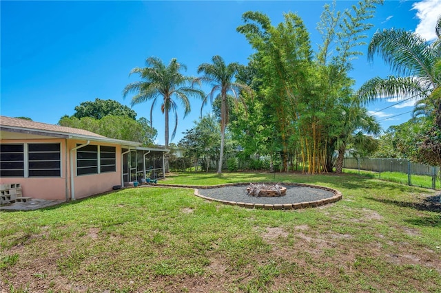 view of yard featuring a fire pit and a sunroom