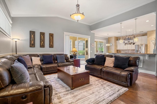 living room featuring ornamental molding, vaulted ceiling, and light hardwood / wood-style floors