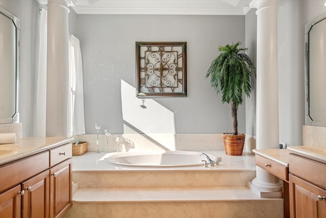 bathroom featuring ornate columns, crown molding, vanity, and a bathtub