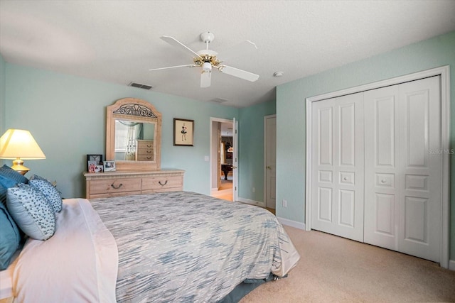 bedroom featuring light colored carpet, ceiling fan, and a closet