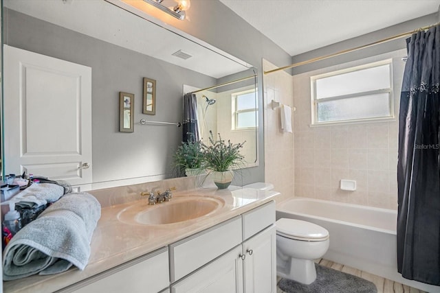 full bathroom with shower / tub combo with curtain, vanity, and toilet