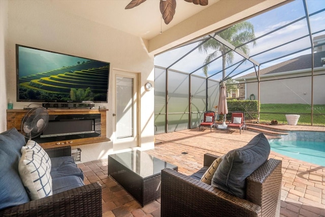 view of patio / terrace with ceiling fan, an outdoor living space, and glass enclosure