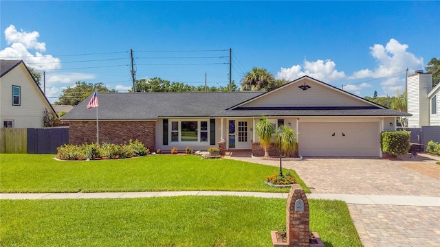 ranch-style home featuring a garage and a front lawn