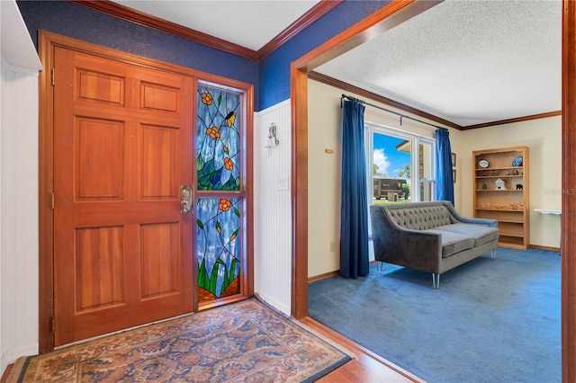 foyer with hardwood / wood-style flooring, ornamental molding, and a textured ceiling