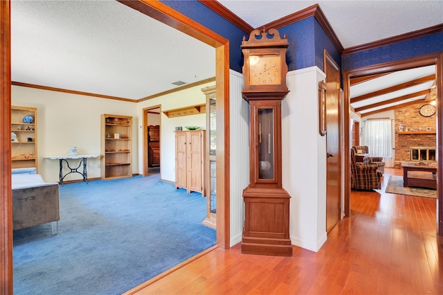 corridor with ornamental molding, lofted ceiling, and hardwood / wood-style flooring