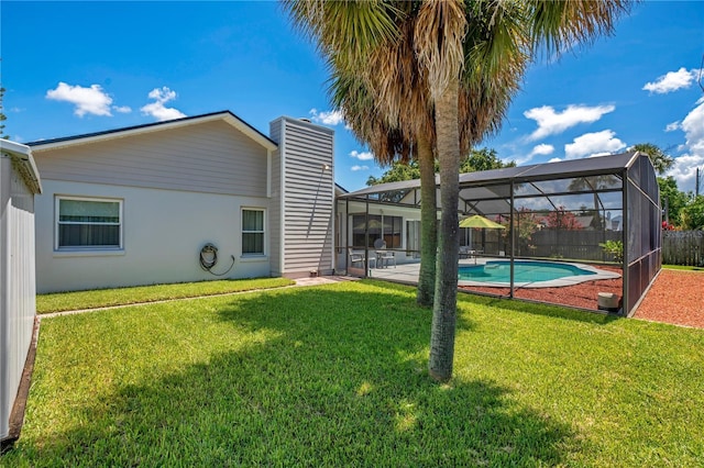 back of house featuring a fenced in pool, glass enclosure, and a yard